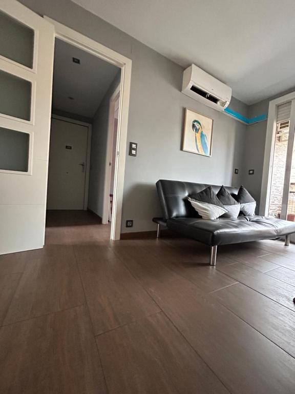 un soggiorno con divano in pelle nera in una camera di Comfortable house a El Prat de Llobregat
