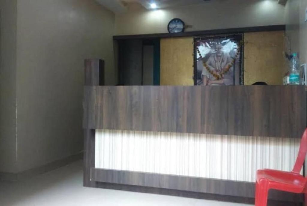 a red chair sitting in front of a reception desk at Hotel Jai Palace Wardha in Wardha