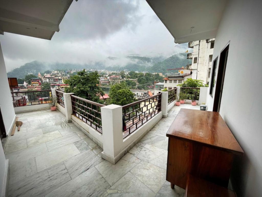 a balcony with a table and a view of a city at Gangesh Hotel in Rishīkesh