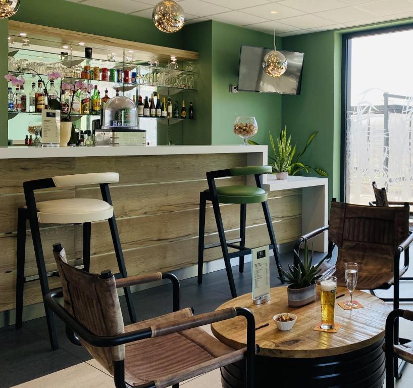 un ristorante con bar con tavolo e sedie di ATOLON PARK HOTEL a Brumath