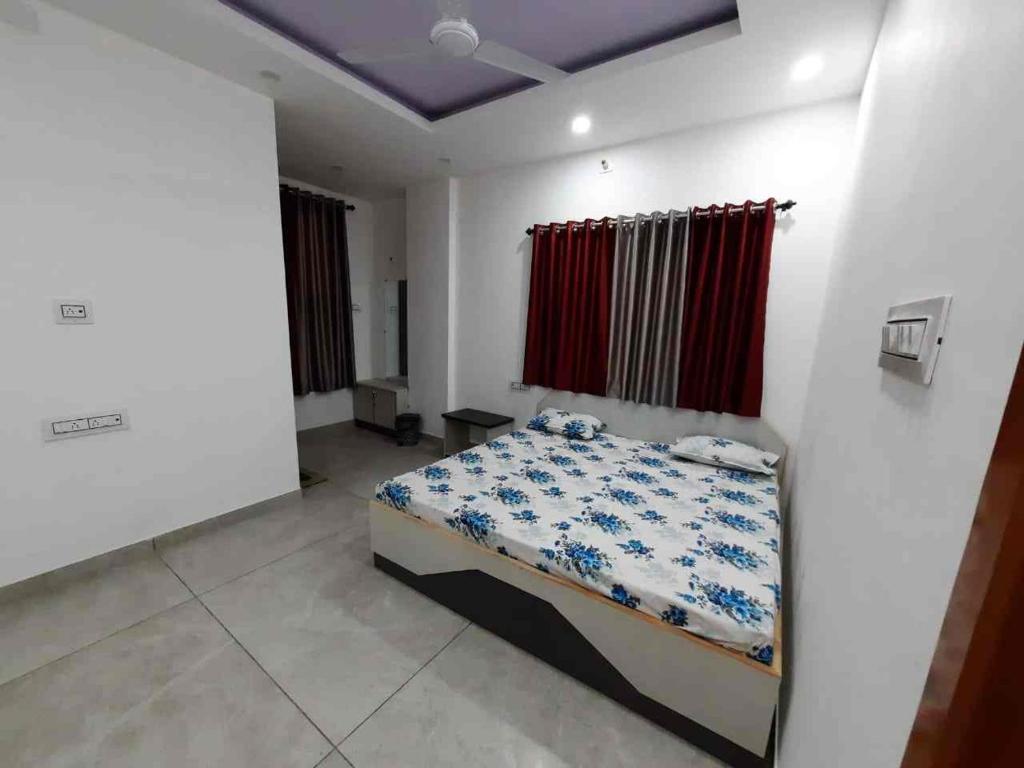 a bedroom with a bed and a red curtain at VTP Guest House in Bikaner