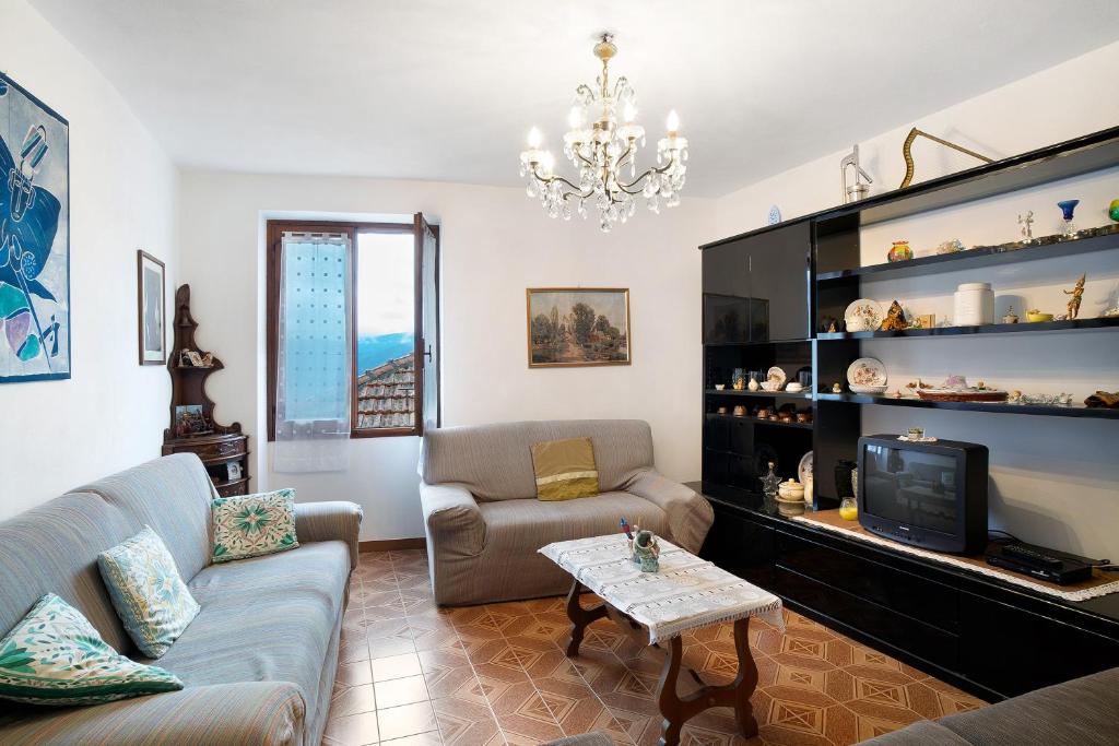 sala de estar con sofá y TV en casa di nonno Pietro, en Pieve di Teco
