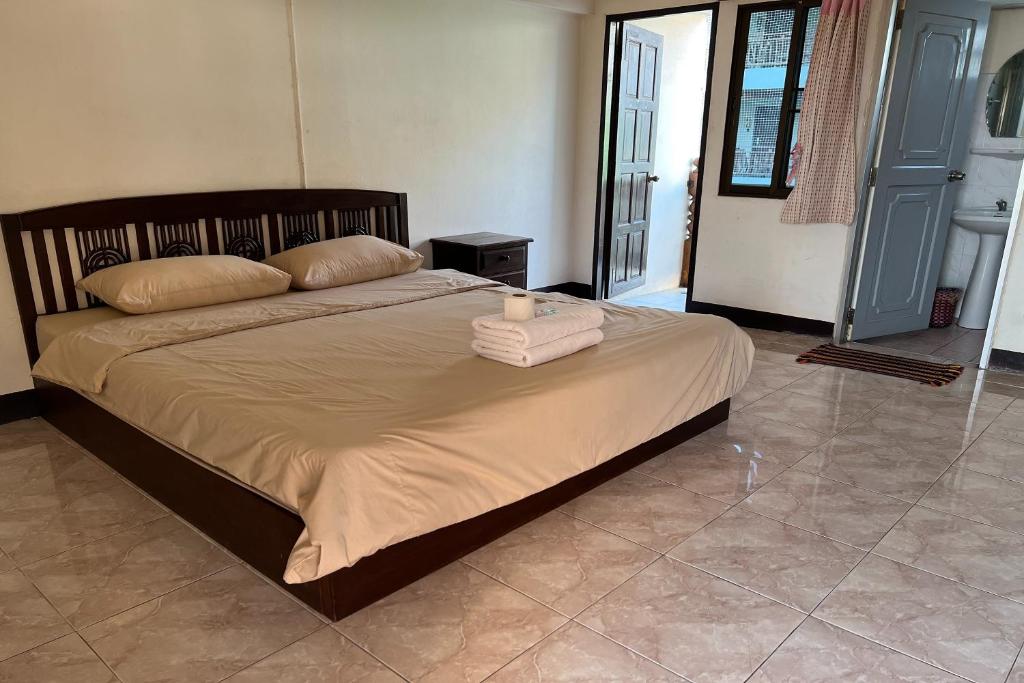łóżko z dwoma ręcznikami i świecą w obiekcie Sripoom House 1 w mieście Chiang Mai