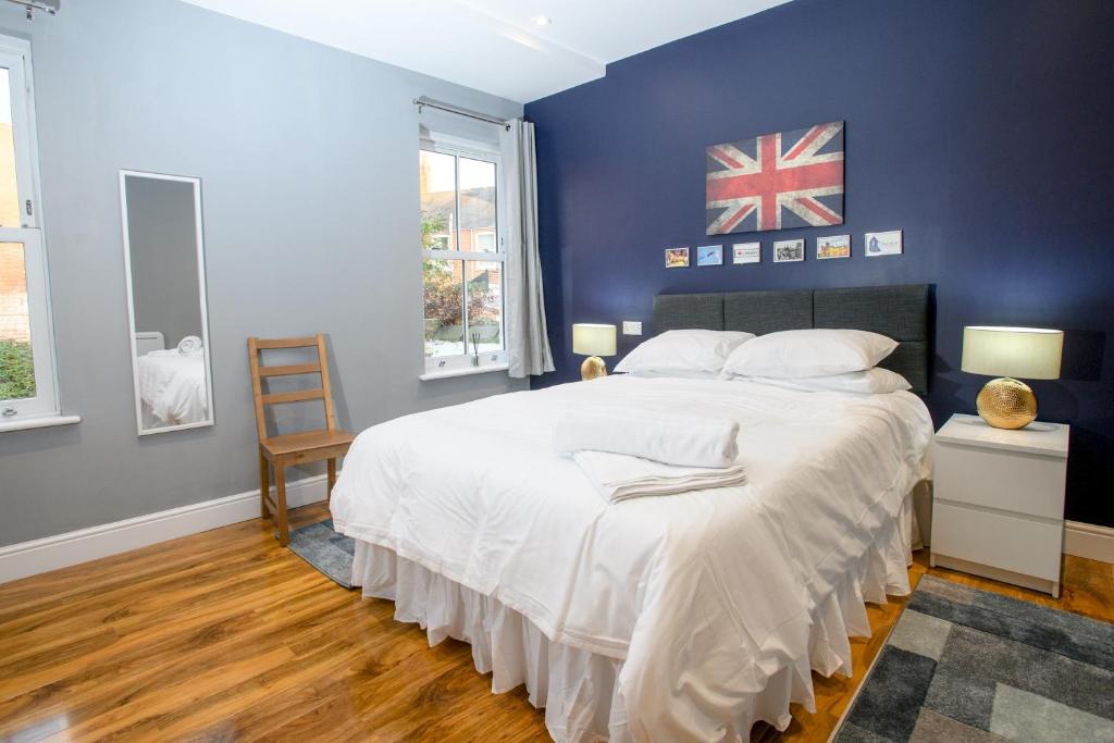 ein Schlafzimmer mit einem großen Bett und einer blauen Wand in der Unterkunft Pass the Keys Lincoln room at Tavmar Apartments in Lincoln