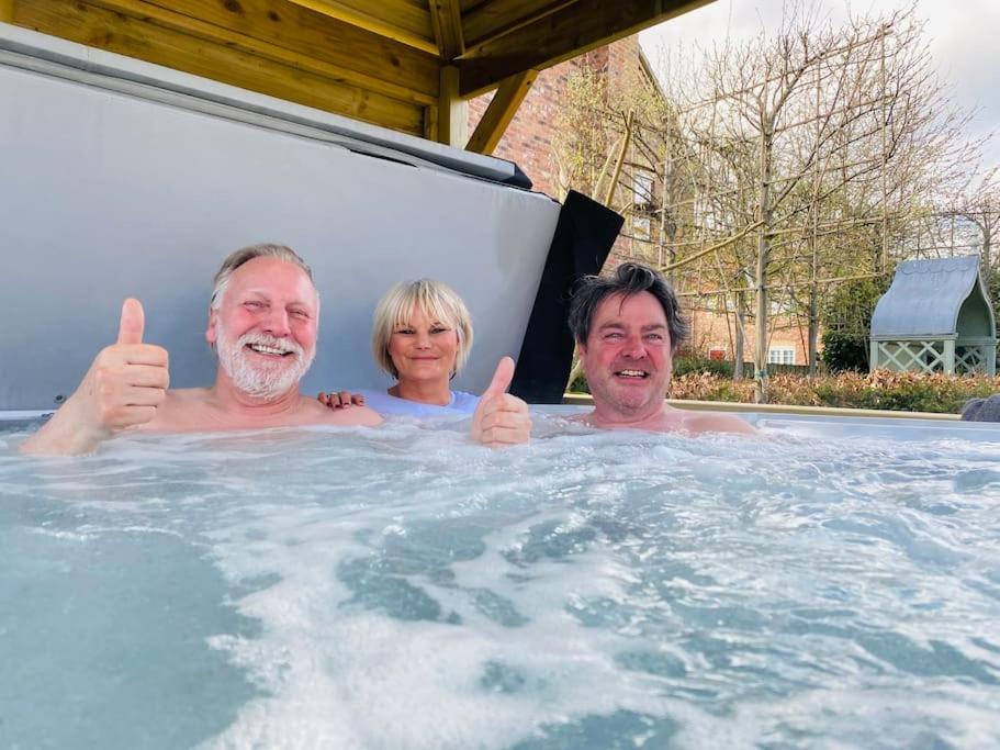 three people giving thumbs up in a hot tub at The Stable's Barn in Bigby in Barnetby le Wold