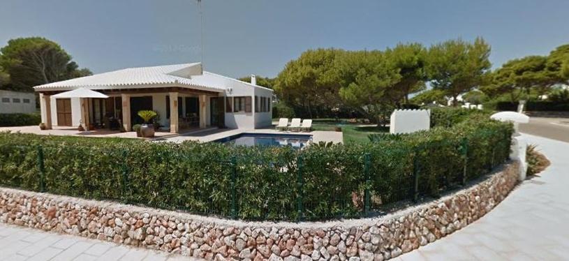 una casa con una pared de piedra junto a un patio en Villa con piscina Cala Morell, en Cala Morell
