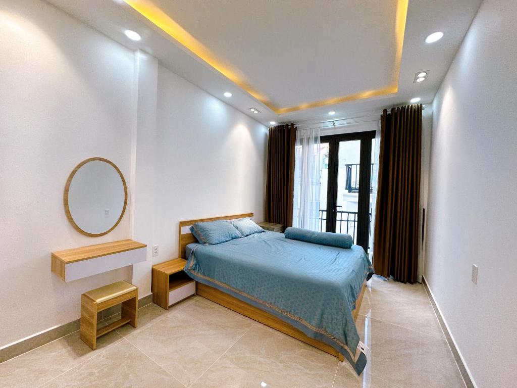 1 dormitorio con cama y espejo en la pared en Alley Homestay Sai Gon, en Ho Chi Minh