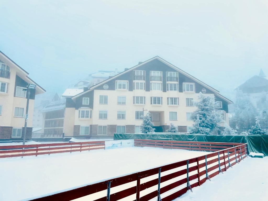 a snow covered building with a fence in front of it at Maribel Chic Shack in Sierra Nevada