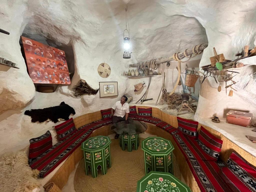 Un homme debout dans une pièce avec un train dans une grotte dans l'établissement Maison d’hôtes Dar Jeddi, à Kreddache