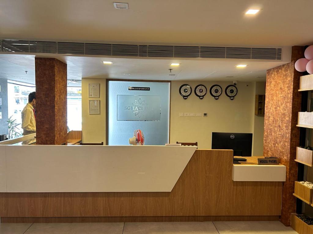an office lobby with a reception counter and a person at SGHACI INN in Kozhikode