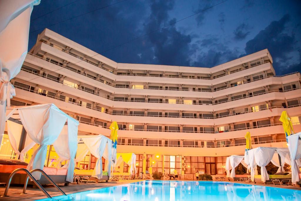 a hotel with a swimming pool in front of a building at Hotel Ambasador Mamaia in Mamaia