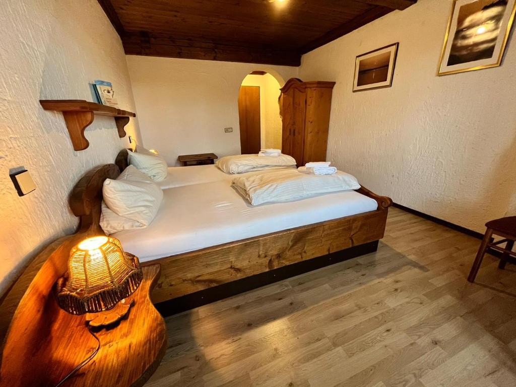 a bedroom with a bed and a lamp in it at Hotel Negele in Hohenfurch