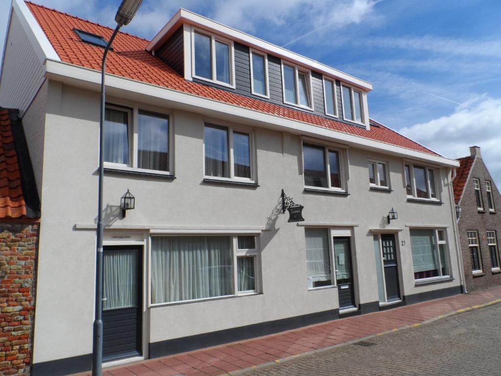 a white house with a red roof at Riemens Residens in Zoutelande