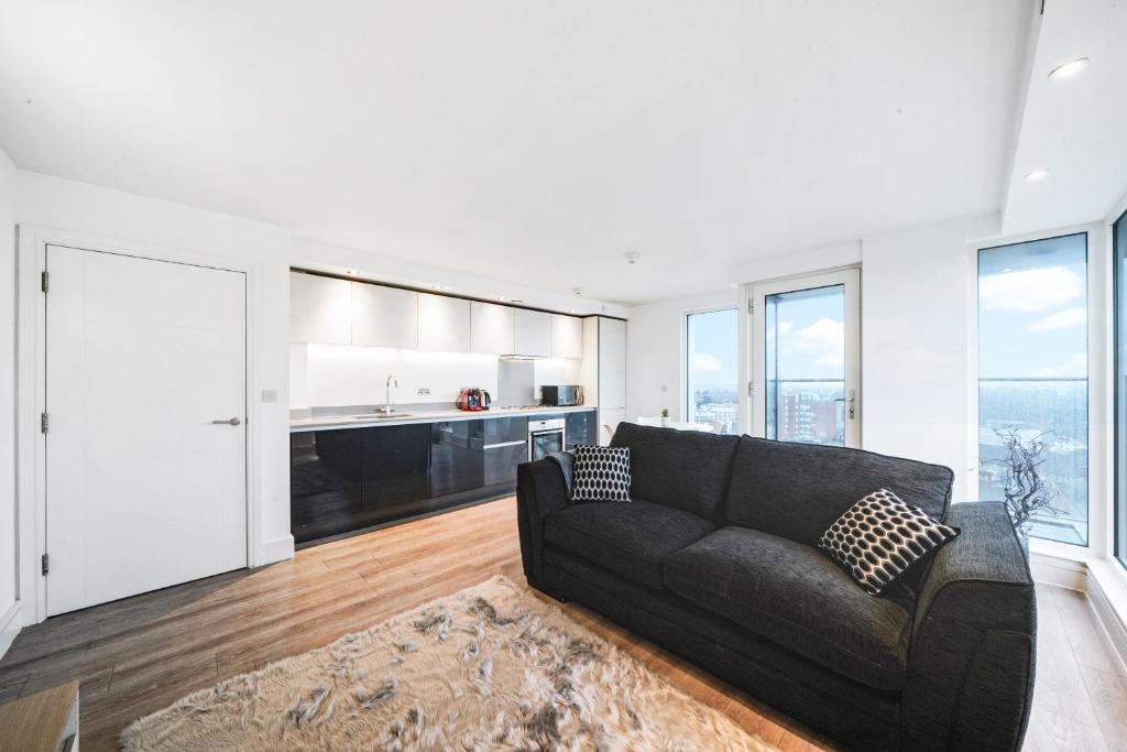 a living room with a couch and a kitchen at Luxury Apartment With Stunning Views on 10th floor in Edgware