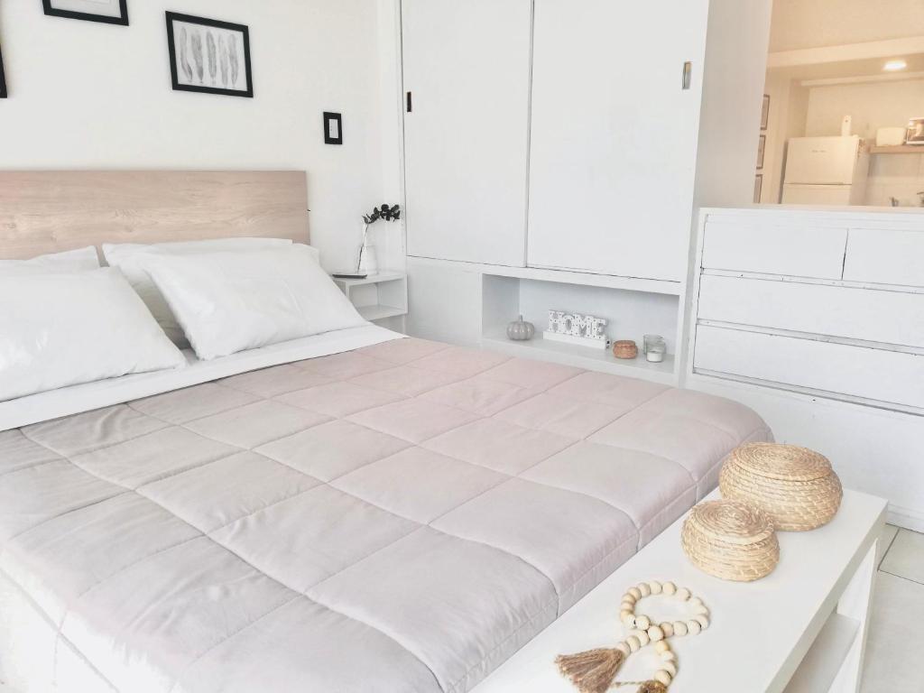 Un dormitorio blanco con una cama grande y una mesa en Lozano Studio en Buenos Aires