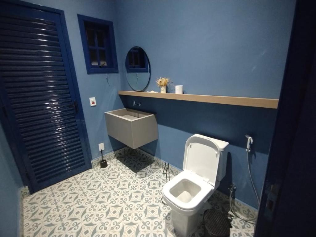 La salle de bains bleue est pourvue de toilettes et d'un lavabo. dans l'établissement Fazenda São Miguel, à Monte Alegre do Sul