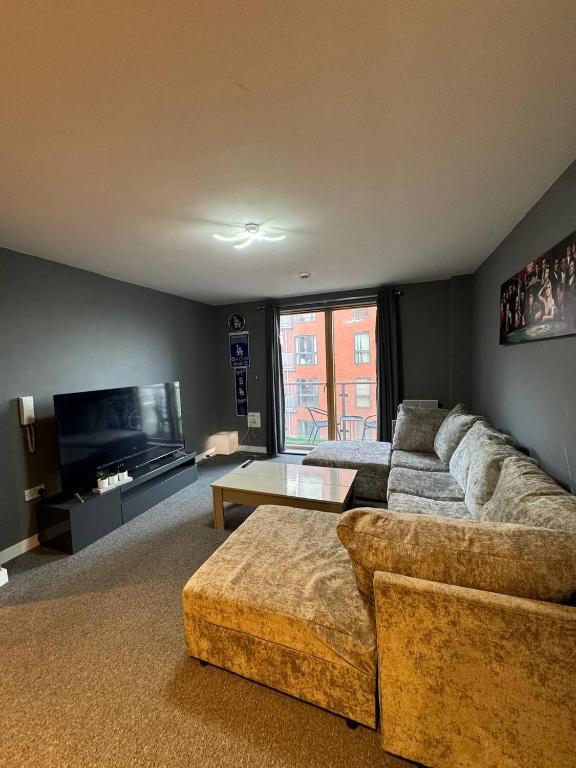 a living room with a couch and a tv at City Centre 1 bedroom apartment in Manchester