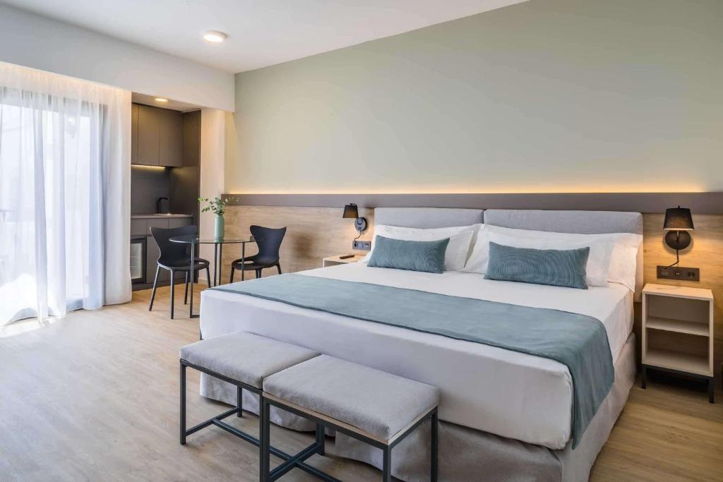 una habitación de hotel con una cama grande y una mesa en Occidental Puerto Banús, en Marbella