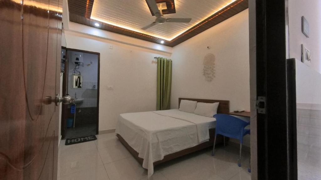 a bedroom with a bed and a blue chair at Goroomgo YP Stays Dehradun - Parking facilities - Best Seller in Dehradun