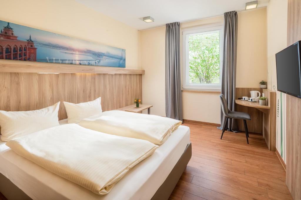 a hotel room with a bed and a desk at Hotel Neumarkt in Berg bei Neumarkt