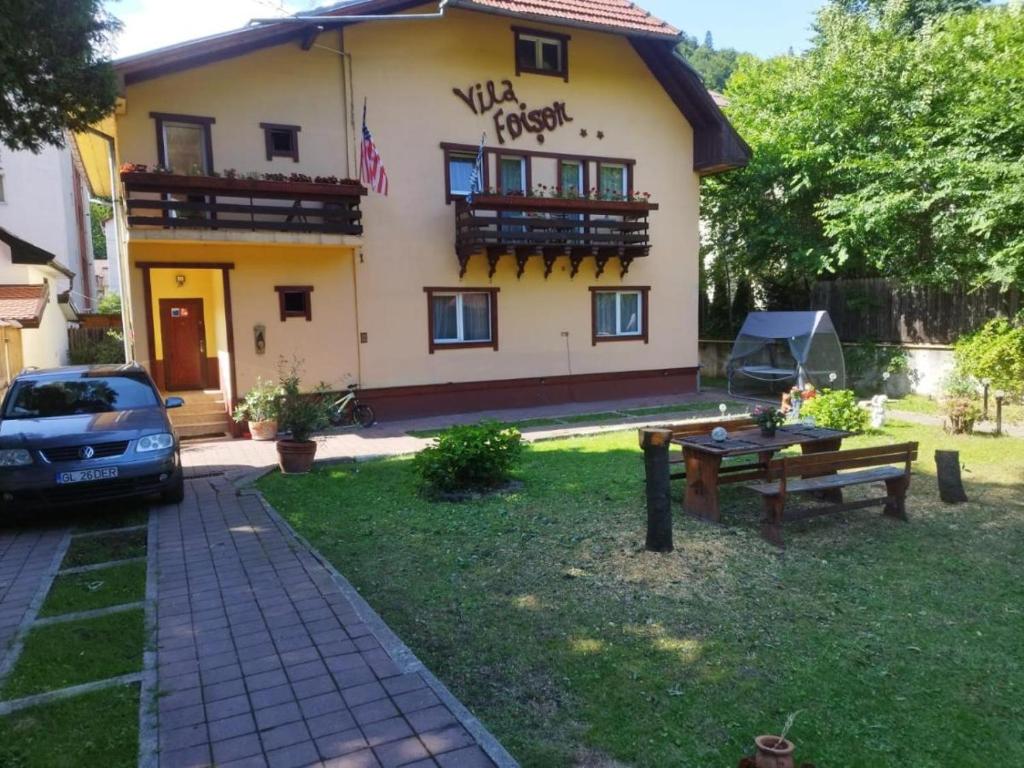 una casa de huéspedes con un coche aparcado delante de ella en Villa Foișor en Buşteni