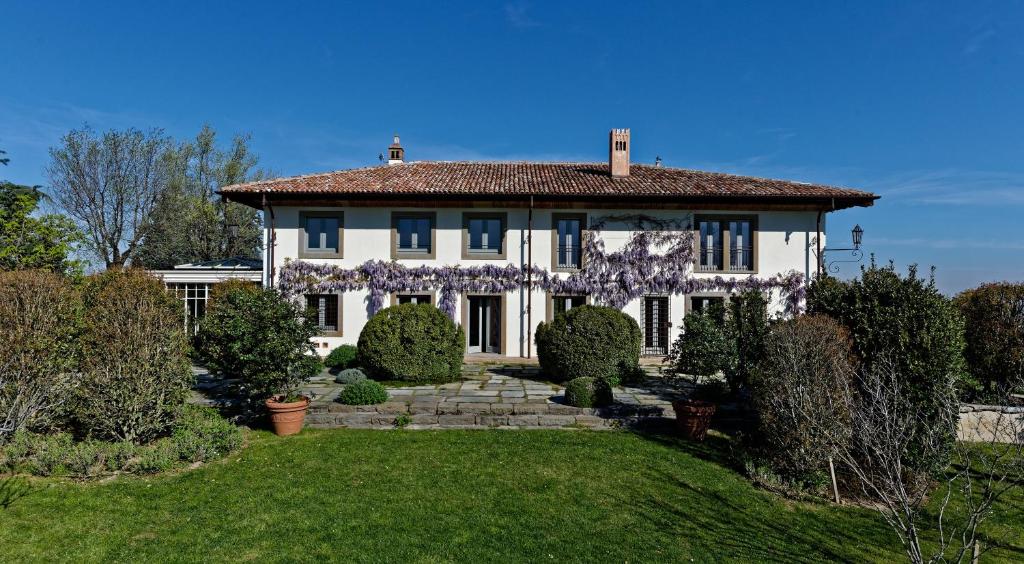 a white house with flowers on the front of it at Villa Amagioia by Palazzo di Varignana in Varignana