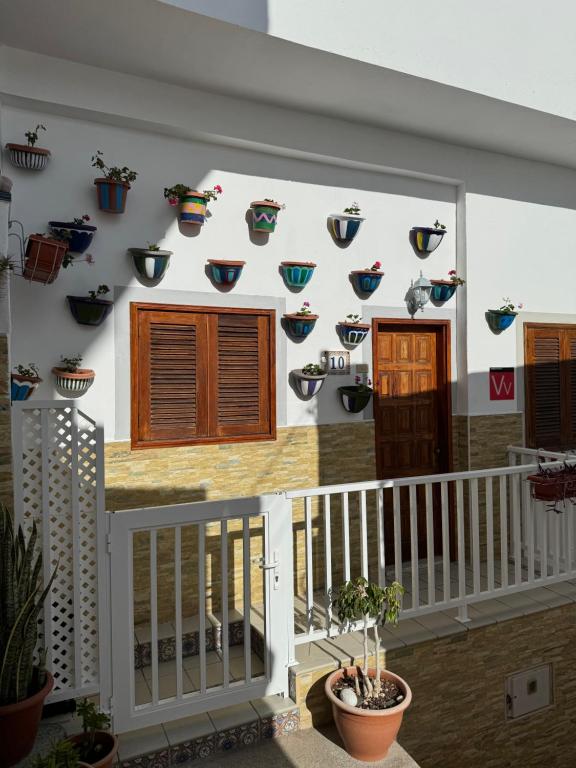 a house with potted plants on the wall at Casa Pepa in Puerto de Mogán