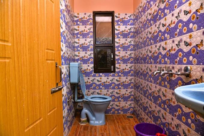 een badkamer met een blauw toilet en een wastafel bij Hang Heem Homestay in Pedong