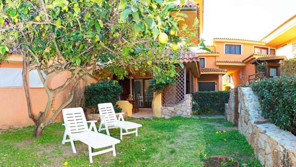 due sedie e un albero di fronte a una casa di Ampio Trilocale sul Golfo di Marinella a Marinella