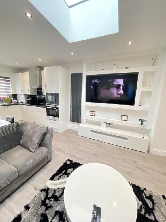 a living room with a couch and a tv at UPPAMOST London luxury home 2 in Dagenham