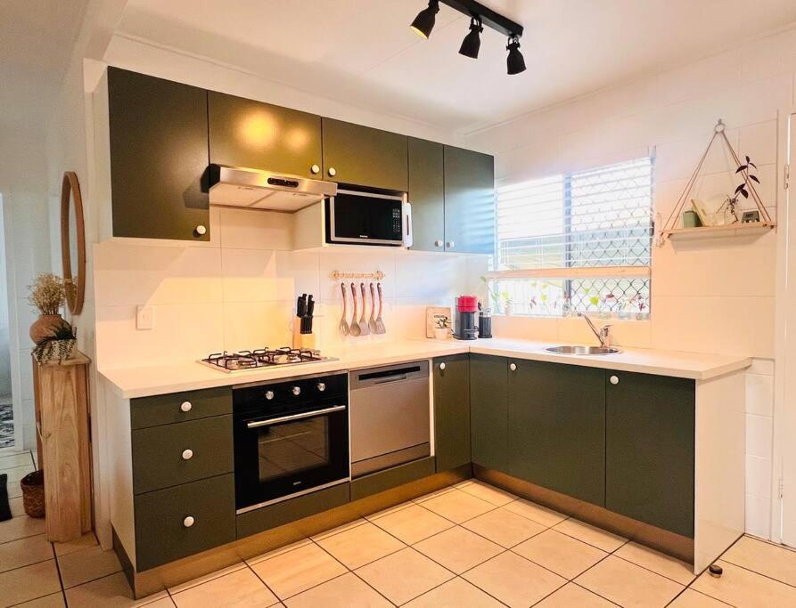 a kitchen with green cabinets and a stove at 'Your Place on Davidson' in Mount Isa