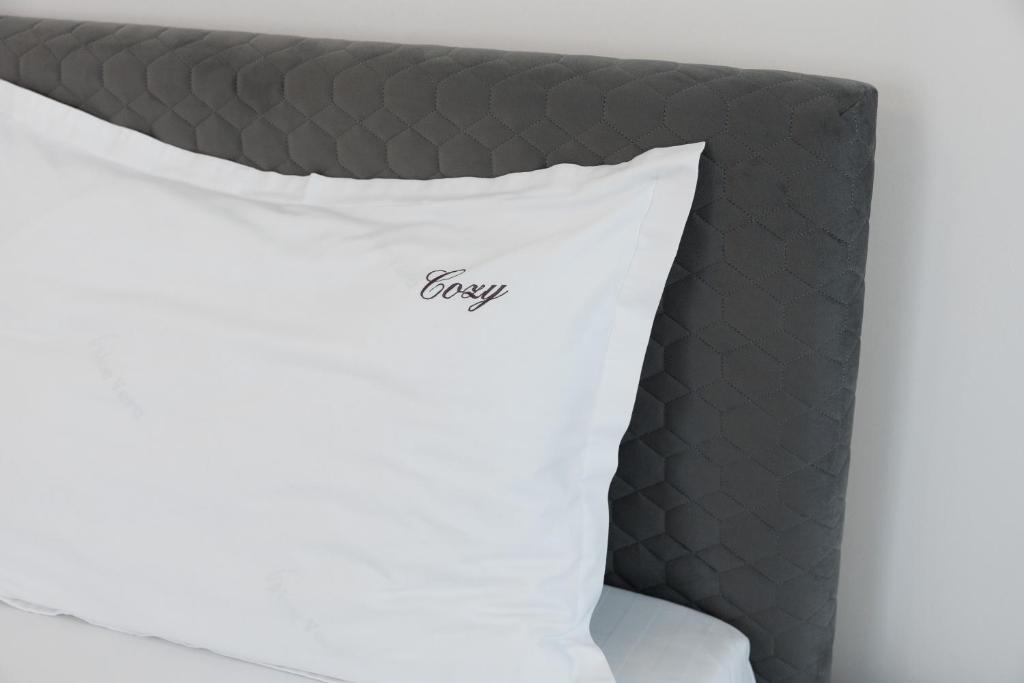 Una almohada en una cama con la palabra reza escrita en ella en Cozy ApartHotel K Suceava, en Suceava