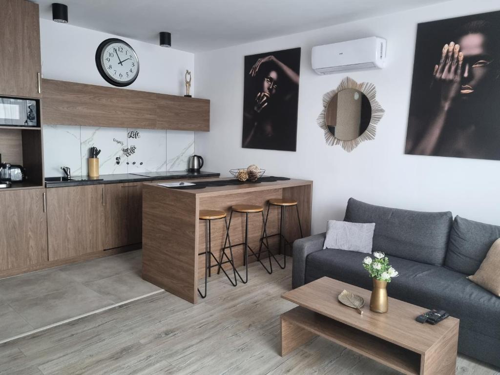 een woonkamer met een bank en een tafel bij Q Apart GRAND - 3 pokojowe klimatyzowane apartamenty przy Manufakturze z garażem Gratis, FV in Łódź
