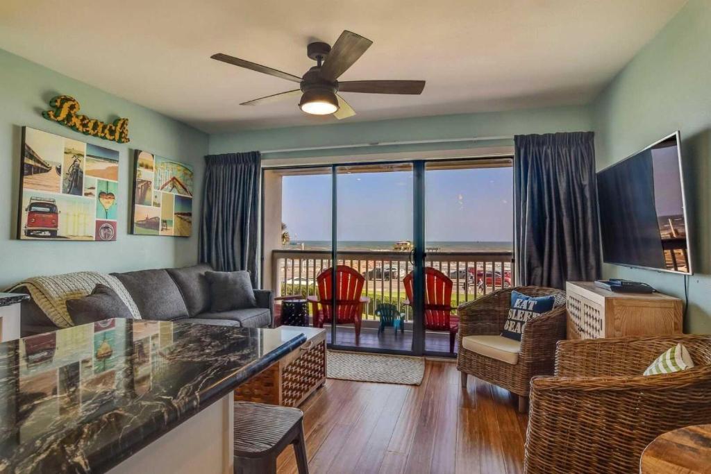 a living room with a couch and a balcony at CDM 201 - Pier Paradise in Galveston