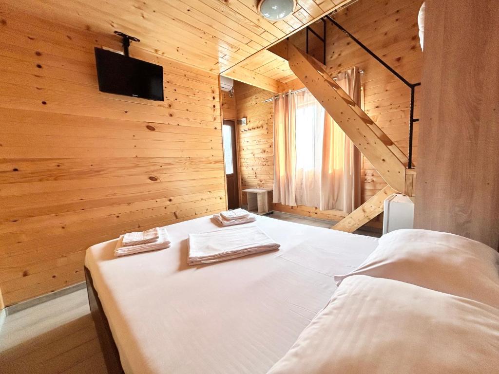 a bedroom with a bed in a wooden room at Cazare Nicoleta in Vadu