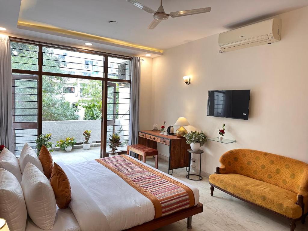 1 dormitorio con 1 cama, TV y sofá en Grove Residency Hauz Khas New Delhi Couple Friendly en Nueva Delhi