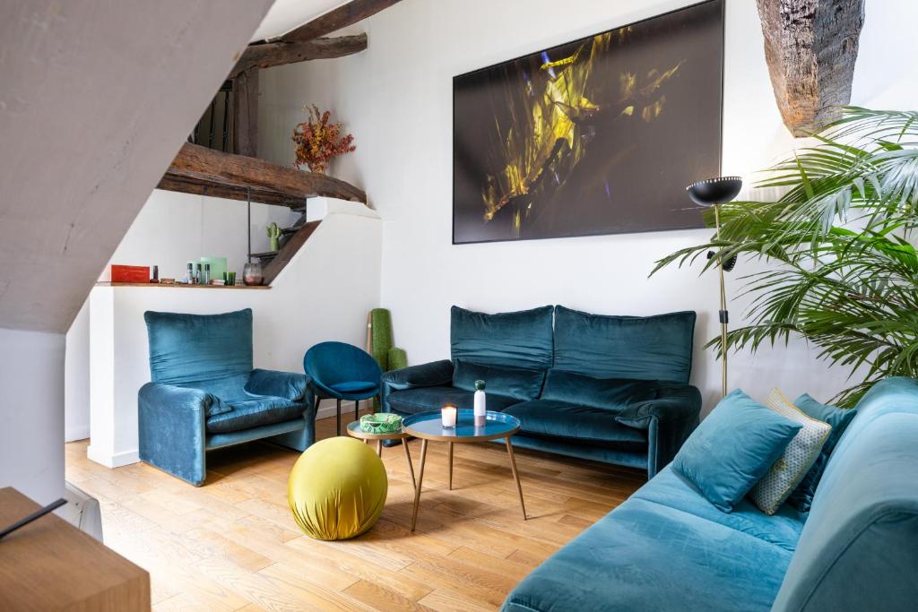 un salon avec deux canapés bleus et une table dans l'établissement L'appartement du Cirque, à Paris