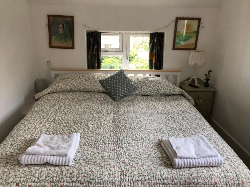 a bedroom with a bed with two towels on it at Barn Corner in Bridport