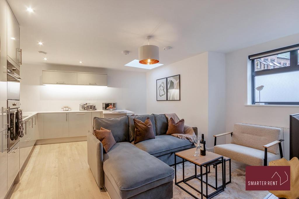 a living room with a couch and a kitchen at Wokingham - 2 Bedroom - Refurbished 1st Floor Flat in Wokingham