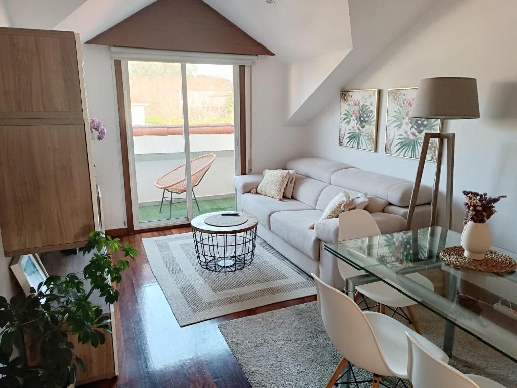 a living room with a couch and a glass table at Acogedor Ático en Nigran in Nigrán