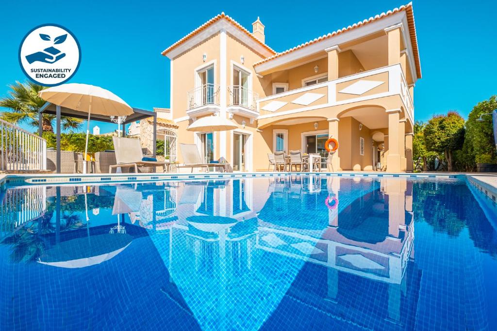 una villa con piscina frente a una casa en Villa Florença by Algarve Vacation, en Albufeira