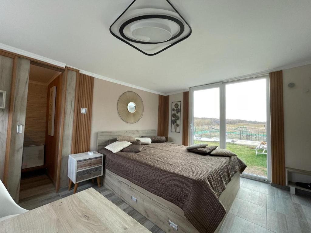 a bedroom with a large bed and a large window at Diamona Lux Spa Apartman in Niš