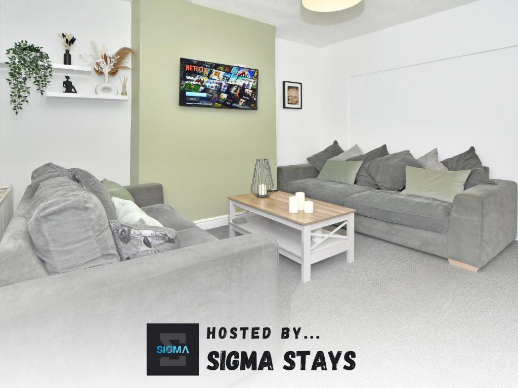 una sala de estar con un sofá y una mesa en Croft House - By Sigma Stays, en Crewe