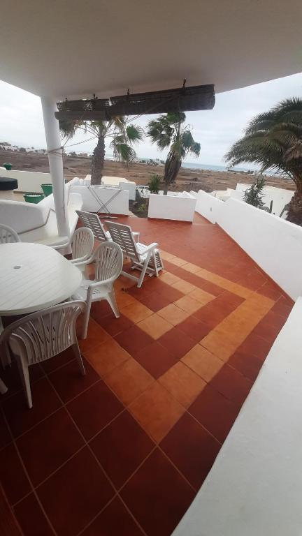 a balcony with a table and chairs and the ocean at Apartamento Cotillo in Cotillo