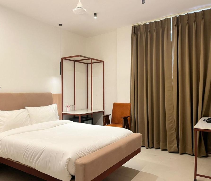 a bedroom with a bed and a large window at HOTEL VARUNA Varanasi in Varanasi