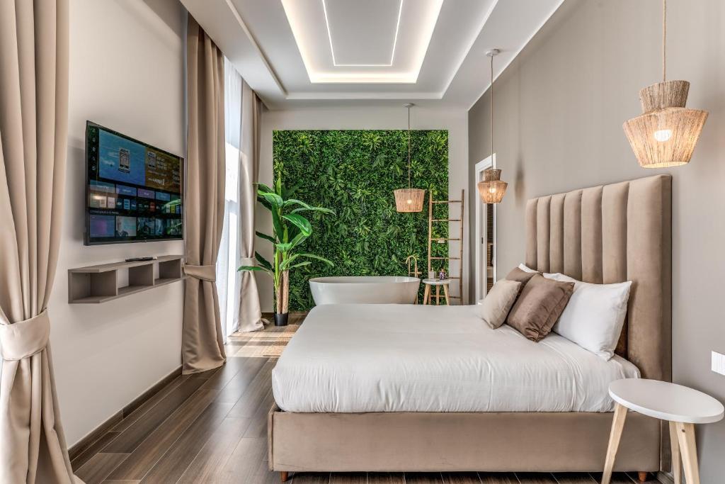 a bedroom with a bed and a tub in front of a window at ATAROOMS Suites Napoli in Naples