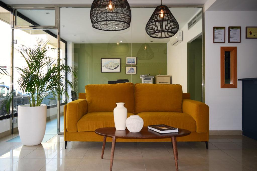 a living room with a yellow couch and a table at Hotel Mirablau in Aguadulce