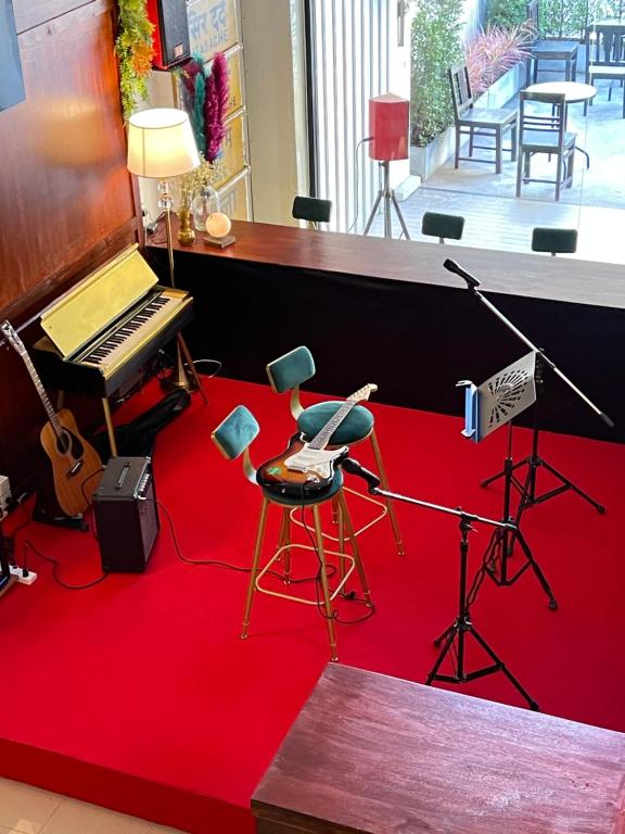 a room with a piano and a red carpet at Wave House Studio Huahin in Hua Hin