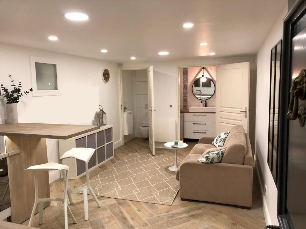 une cuisine et un salon avec un canapé et une table dans l'établissement Cosy Studio, à Colombes