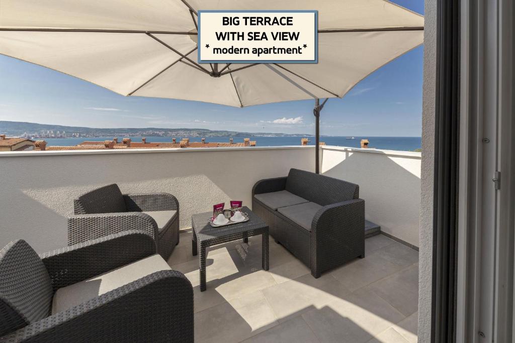 a balcony with two chairs and an umbrella at Apartments ERA Ankaran in Ankaran